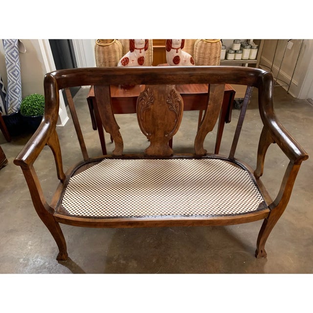 Victorian bench with detailed carving in the center back and newly upholstered cushion with zipper.