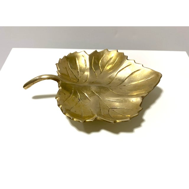 A charming mid-century brass trinket dish in the form of a maple leaf. The sculpted veins and naturalistic form create a...
