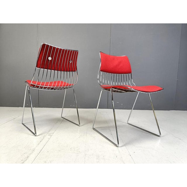 Set of 8 stackable dining chairs designed by Rudi Verelst. The have a heavy wired chrome frame with newly upholstered red...