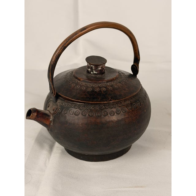 An attractive antique Himalayan/Tibetan copper tea or water kettle, of rounded form with a removable domed lid, short...