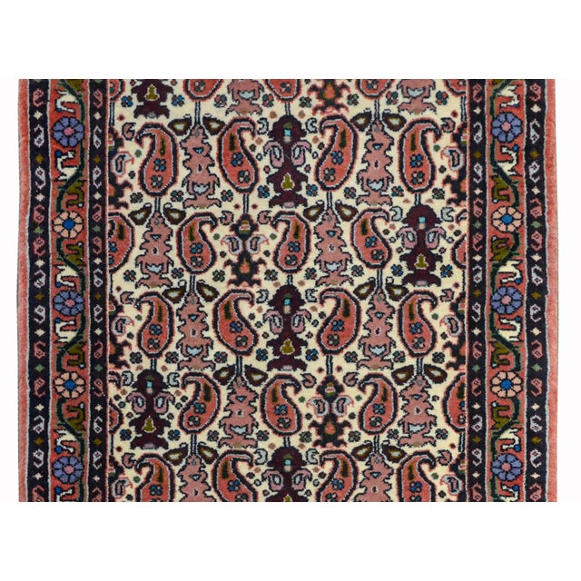 A wonderful vintage petite Persian Bidjar rug with an all-over paisley pattern woven in dark and light red, light indigo,...