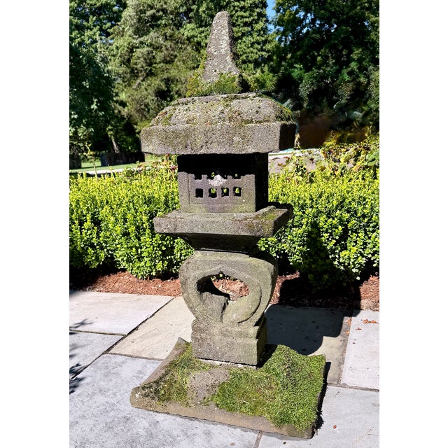 A substantial Japanese-style composition stone garden lantern with a beautifully weathered surface and a rich covering of...