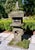 A substantial Japanese-style composition stone garden lantern with a beautifully weathered surface and a rich covering of...
