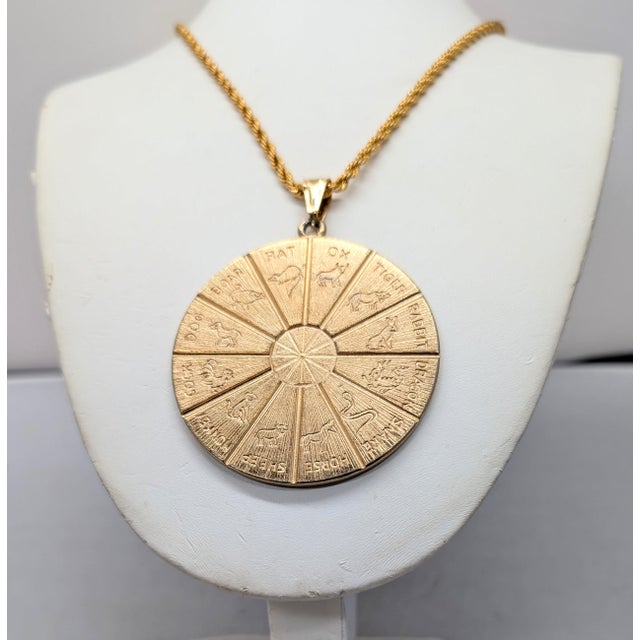 1970s goldtone round engraved horoscope pendant necklace with spring ring clasp. Marked "NAPIER©" on the back. Pendant...