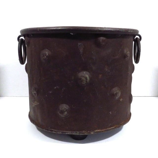 Handmade distressed metal footed planter with hammered dot decoration and ring handles. The metal has taken on a rusted...