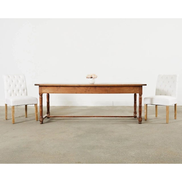 Modern set of fourteen upholstered dining chairs featuring a button tufted, scrolled back, crafted with a hardwood frame...