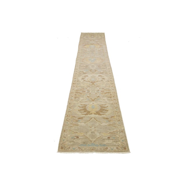 This hand-knotted wool rug has a beige background adorned with a blue and brown all-over design. This rug measures 3'2'' x...