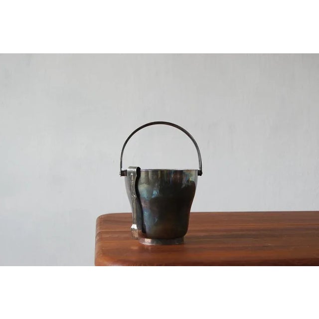 This is a stylish ice bucket in the modernist style . It dates back to the 1930's and is silver plated . It makes a...