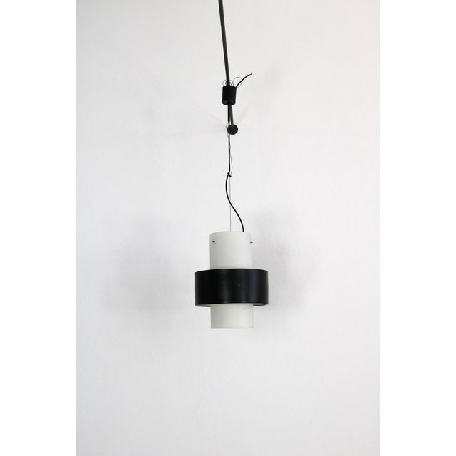 1950s Stilnovo pendant lamp made of satined glass with black painted aluminum ring. The lamp is in a very nice original...