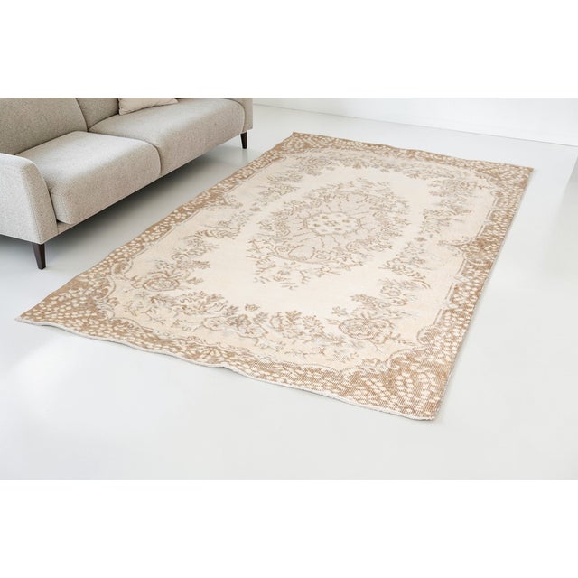 This is a vintage Turkish Oushak rug from the Mid 20th Century. The piece was hand-knotted.