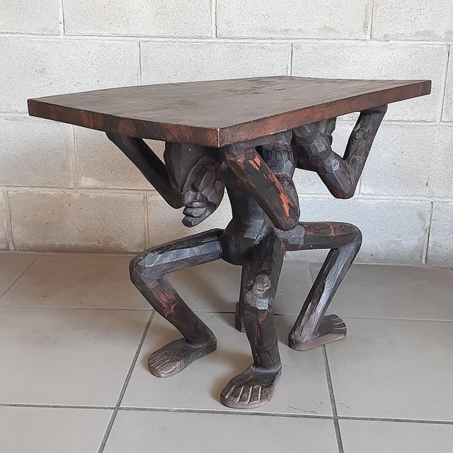 Beautiful ethnic coffee table in solid wood, entirely hand-carved. The base is composed of two kneeling human figures,...