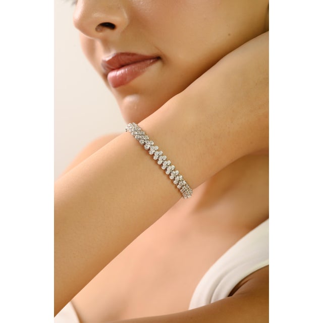 Make every moment shine with this Navette Art bezel-set CZ tennis bracelet, expertly crafted in 925 sterling silver. The 2...