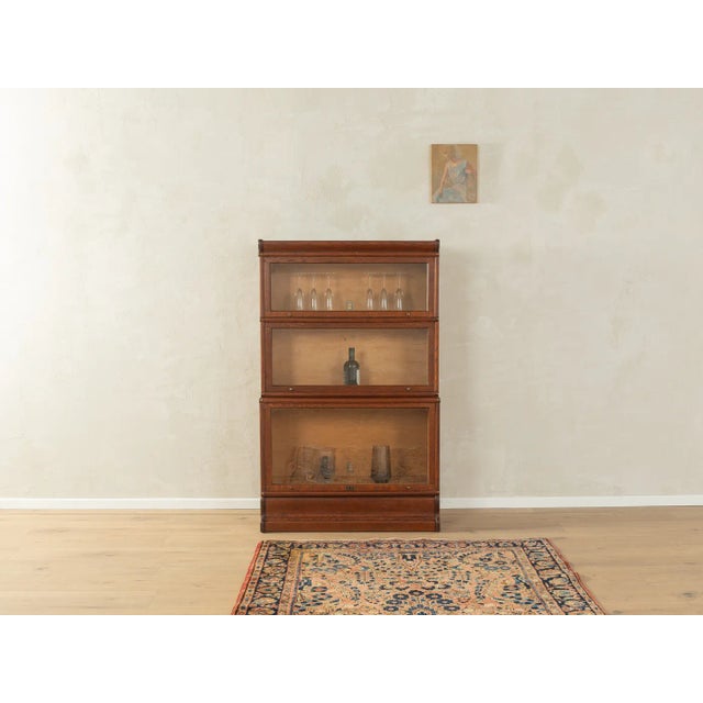 Modular antique book display cabinet from the 1900s. High-quality three-part body made of dark-stained oak with...