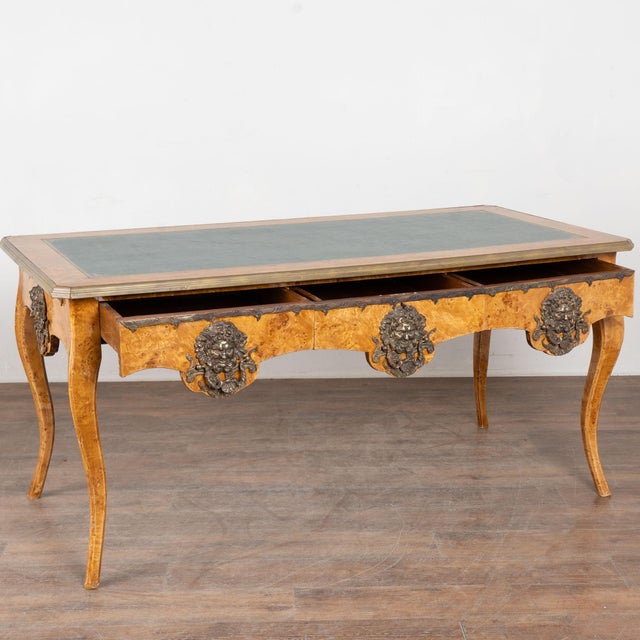 Early 20th century Louis XV style writing desk crafted in burlwood. The desk features the original green leather writing...