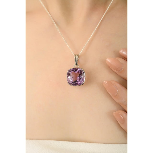 This beautiful pendant is designed with a stunning 14.37 carat cushion-cut Amethyst gemstone set in shiny 925 silver. The...