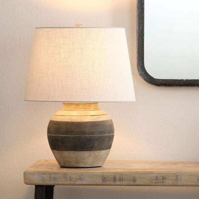 This beige and dark grey ceramic table lamp may be small in stature, but its alternating stripes add a bold touch to the...