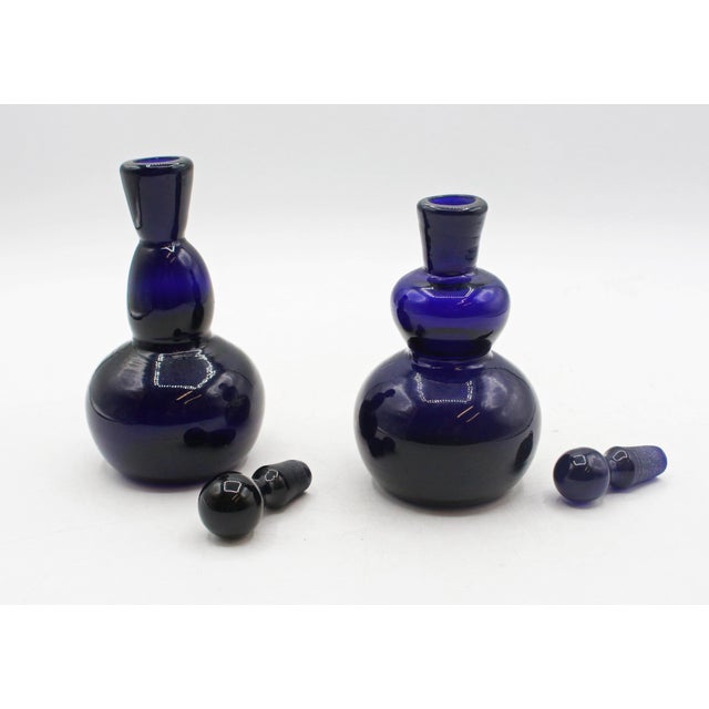 An assembled pair of cobalt glass perfume bottles, circa 1950s, likely Denmark. Attributed to Holmgaard, likely by Jacob...