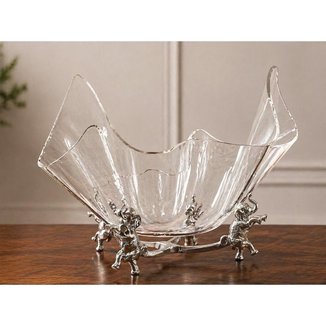 Offering a whimsical Arthur Court serving bowl. This timeless piece is anchored by four standing elephants and topped with...