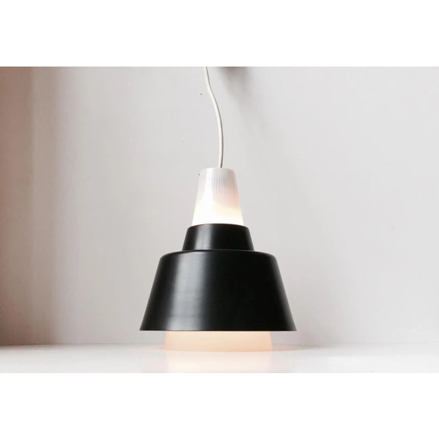 This Italian pendant lamp is composed of thin pinstriped opaline glass and a black lacquered metal shade. It was...