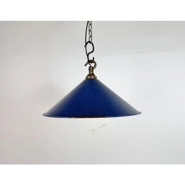 Industrial blue enamel factory pendant light made in United Kingdom during the 1950s. White enamel inside the shade. Brass...