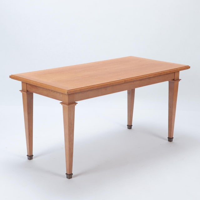 An elegant solid oak library table having a rectangular top with finely molded edge, raised on four square tapering legs...