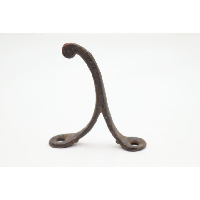 Vintage single arm black finished cast iron wall hook with a ball tip. The original mounting screws are not available....