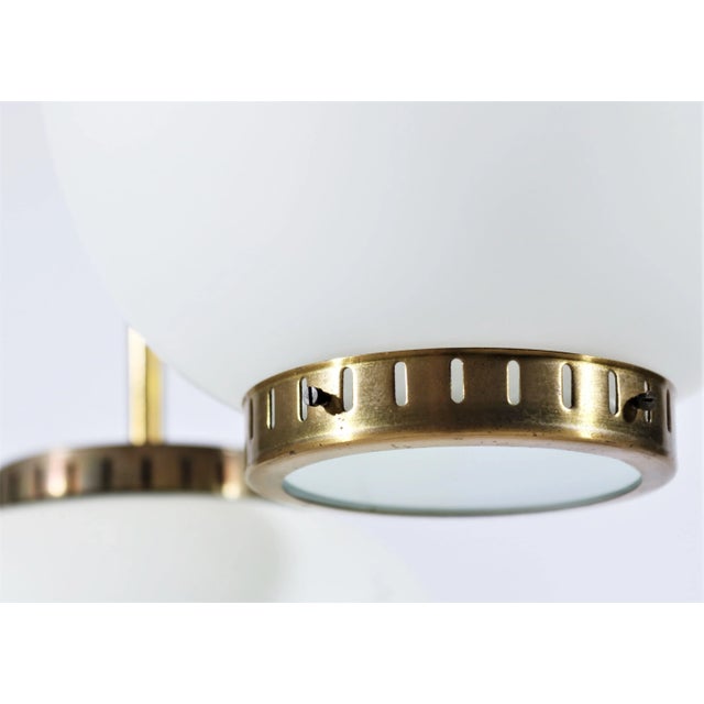 1950s Danish chandelier in patinated brass and shades of matte opal glass with brass fitting. The hanging shades can be...