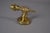 Brass wall sconce in the Art Deco hand-and-torch form, 1930s. A modeled clenched fist grips a fluted torch-form fitting,...