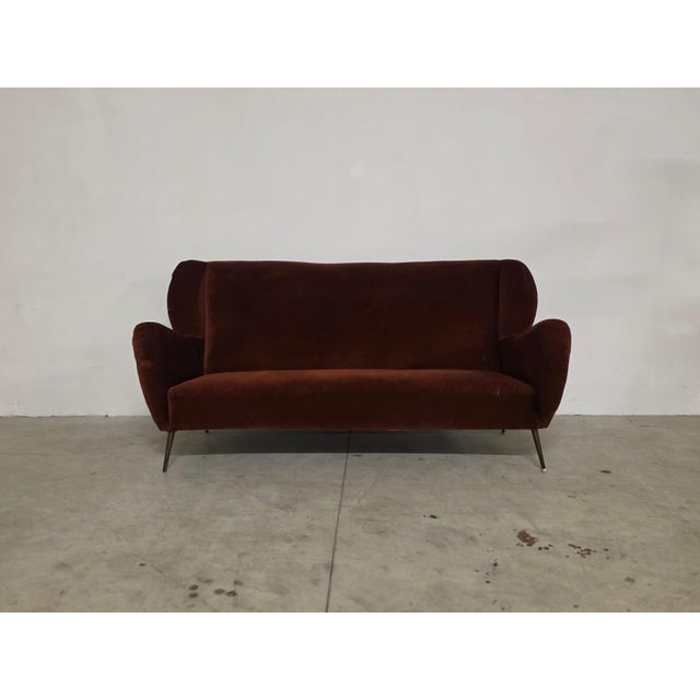 Three-seater velvet sofa from the 1950s. Made in Italy. Refined three-seater sofa with sinuous curved armrests....