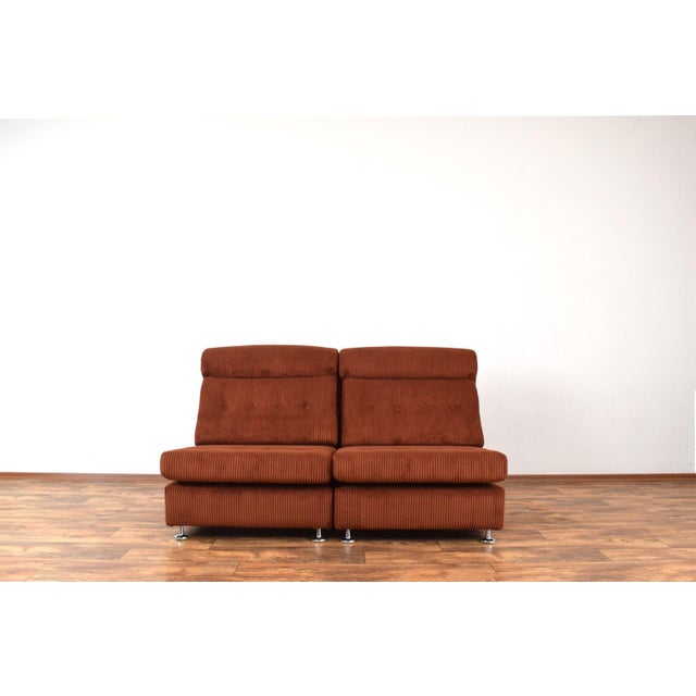 This set of 2 Italian armchairs from the 70s that can be combined to form a two-seater sofa by using metal handles located...