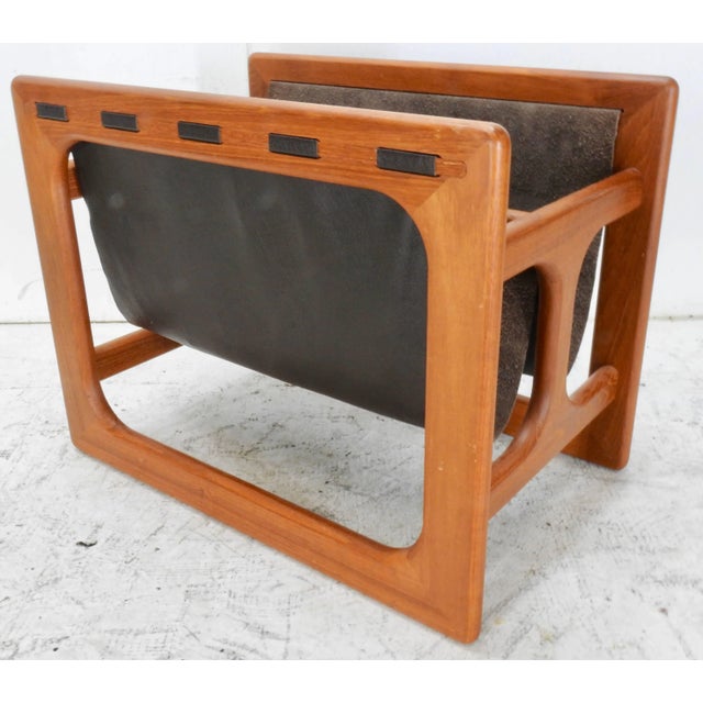 This is a very nice Danish Modern teak and dark brown leather magazine rack designed by Salin Møbler. The 1980s era...