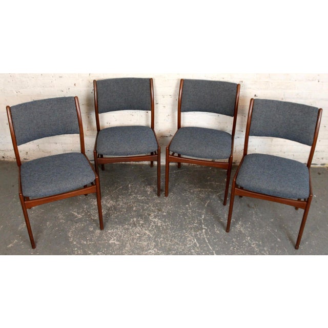Set of four Mid-Century Modern teak dining chairs, newly reupholstered for a fresh, updated look. The chairs feature...