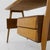 A modernist desk crafted from teak and beech. The rectangular top features a natural teak finish and is supported by four...