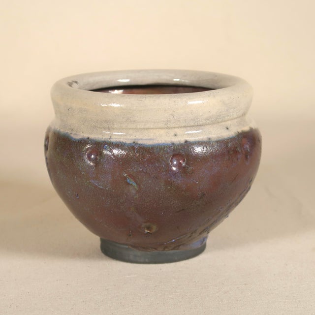 A striking vintage studio pottery vessel featuring a richly atmospheric raku-fired surface. The form is finished in a warm...