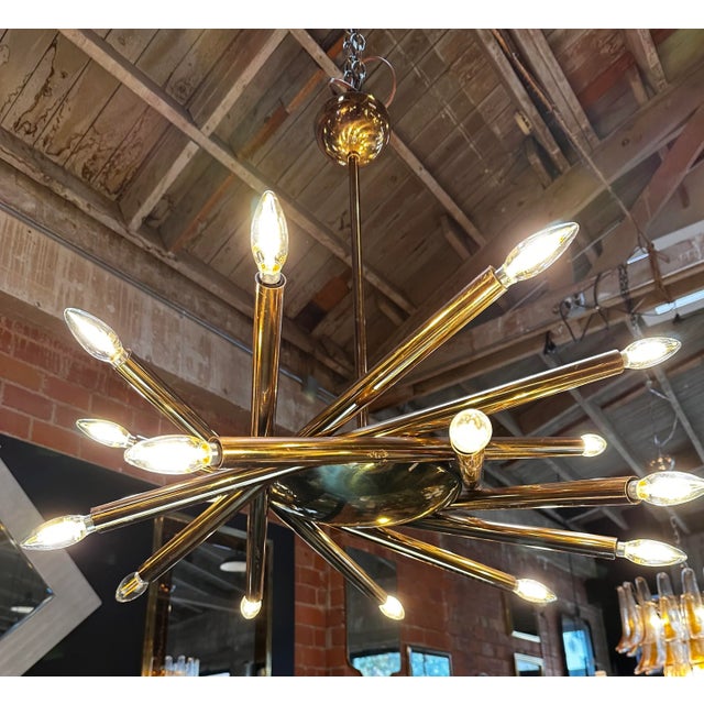 The Mid Century Italian Stilnovo Orbit Chandelier, crafted in brass and originating from Italy in 1955, is a stunning...