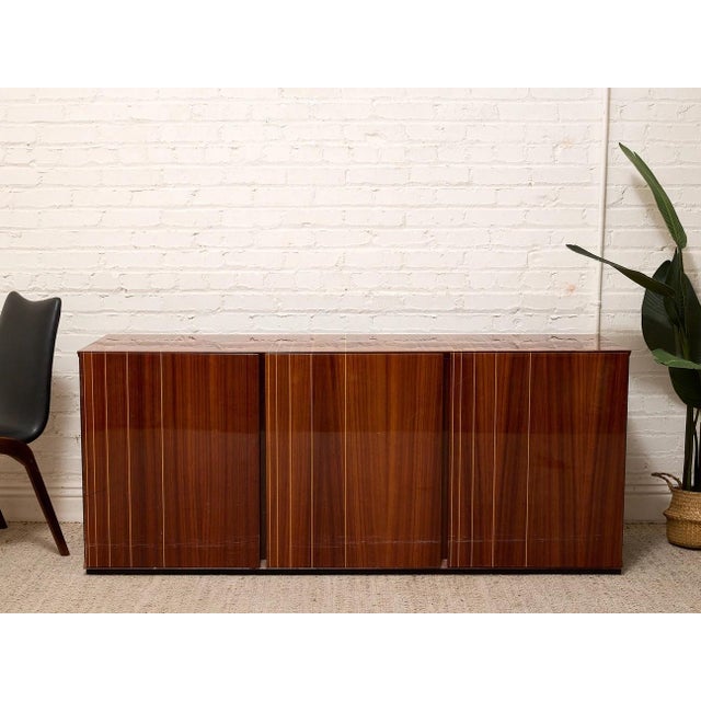 Vintage Italian High-Gloss Wood Three -Door Credenza is a striking vintage credenza made in Italy, defined by its...