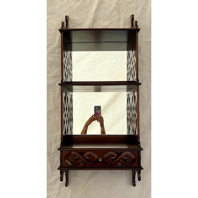 This vintage wall-mounted étagère dates to approximately the early mid-century (likely the 1930-1940's) and is crafted...