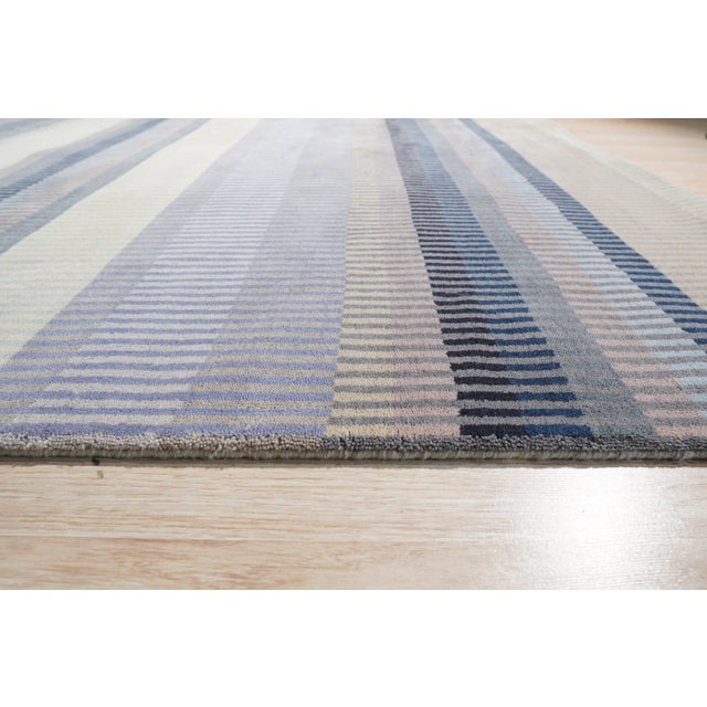 A hand-knotted wool rug, made in India and measuring 4' x 6'. Geometric drawing - repeating motifs held inside strong...