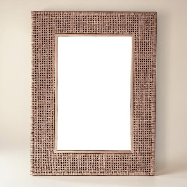 This handcrafted cane-framed wall mirror is a sculptural nod to the intersection of natural form and refined function....