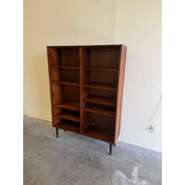 Danish Mid-Century Modern bookcase crafted in richly grained rosewood, made in Denmark, circa 1960s. This piece showcases...