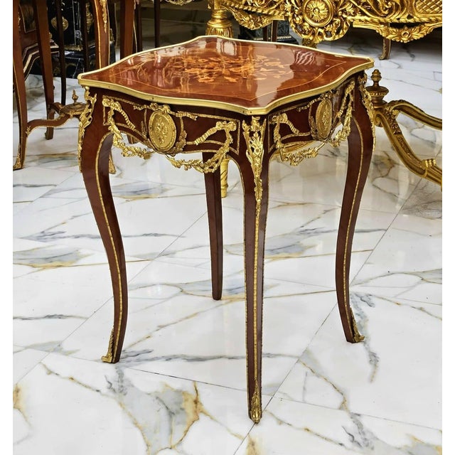 Elegant French-style side table featuring a sophisticated glass top that beautifully showcases the decorative artwork...