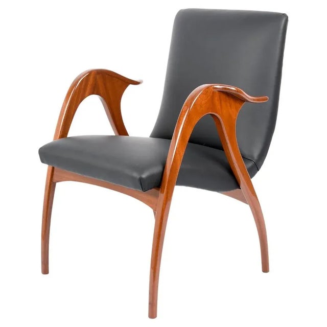 Incredible Mid-Century armchair in walnut and black leather. This fantastic piece was designed by Malatesta & Mason and...