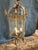 A striking French Louis XV–style brass hall lantern featuring a rectangular glass-paneled body framed by ornate Rococo...