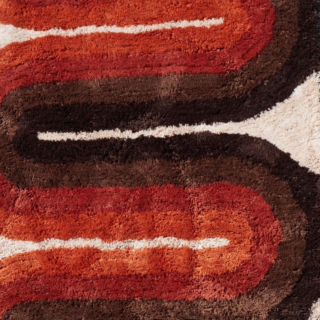 1970's wool pop-art style shag wall tapestry. The tapestry features a beige background and a wave design in black, brown,...