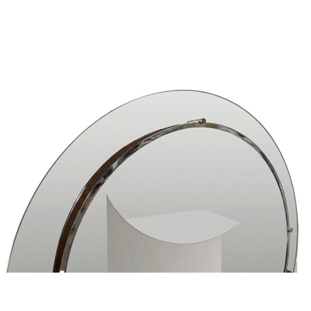 This is a circular wall mirror composed of two overlapping discs. The front one is smaller and central, with a slanted...