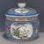A vibrant Chinese porcelain covered jar featuring a bright blue ground. The jar is elaborately decorated with colorful...