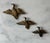 Set of 3 vintage mid century modern brass flying ducks or geese wall plaques. The set features varying sizes and built in...