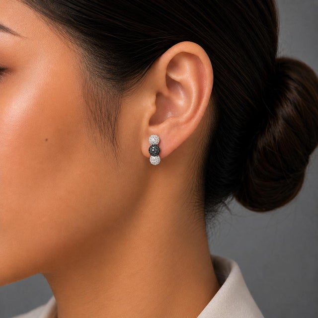 18K White Gold Black and White Diamond Ball Sphere Earrings. This elegant pair features numerous brilliant round white...