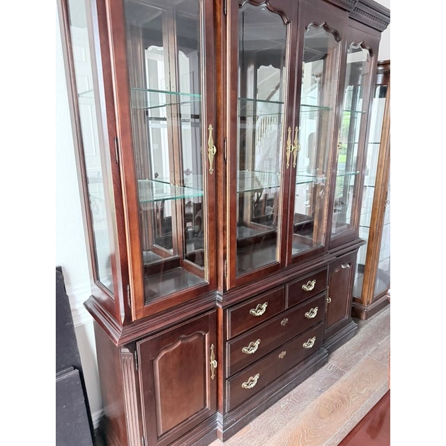 An impressive large china cabinet in dark mahogany with multiple glass-panel doors, adjustable glass shelves, and a...