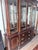 An impressive large china cabinet in dark mahogany with multiple glass-panel doors, adjustable glass shelves, and a...